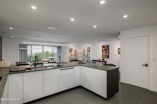 kitchen featuring white cabinets, kitchen peninsula, and sink