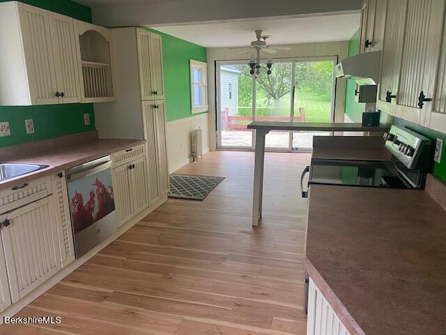 kitchen with radiator, ceiling fan, dishwasher, light hardwood / wood-style flooring, and range