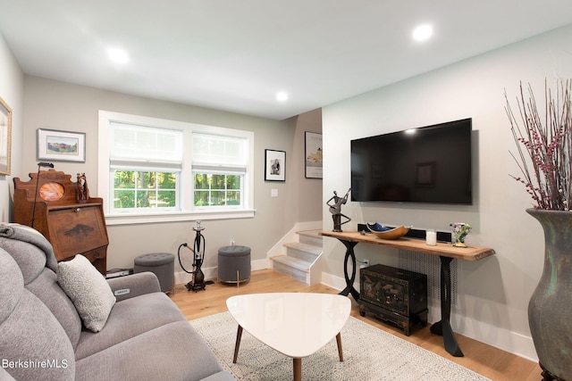 living room featuring stairs, baseboards, wood finished floors, and recessed lighting