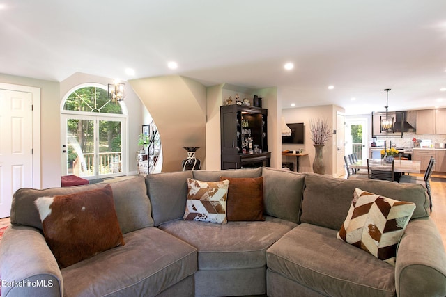 living area featuring a wealth of natural light, wood finished floors, a notable chandelier, and recessed lighting