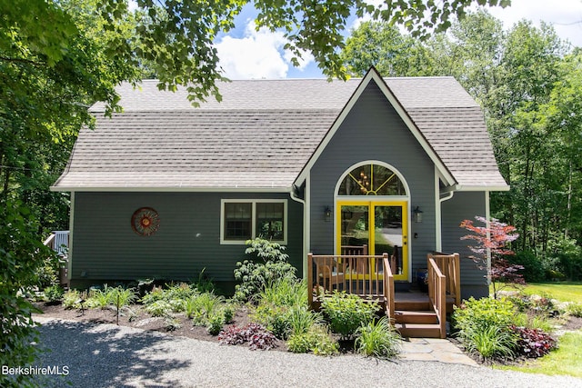 view of front facade with a deck and a shingled roof