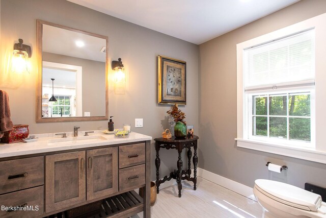 bathroom featuring vanity, toilet, and baseboards