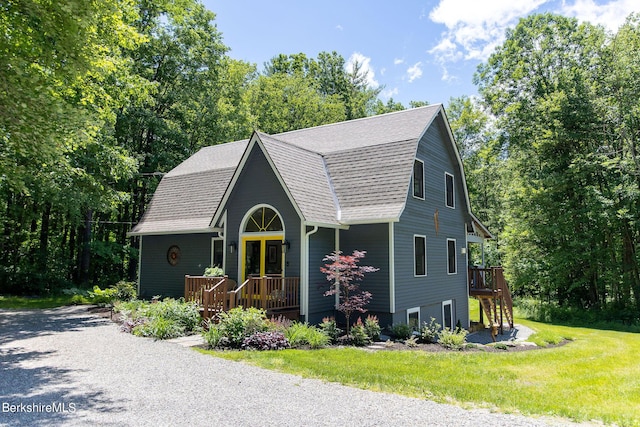 colonial inspired home with a front lawn and roof with shingles