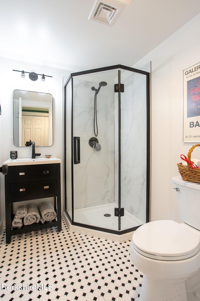 full bath featuring visible vents, vanity, a marble finish shower, and toilet