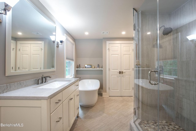 bathroom featuring a stall shower, visible vents, a freestanding tub, and vanity