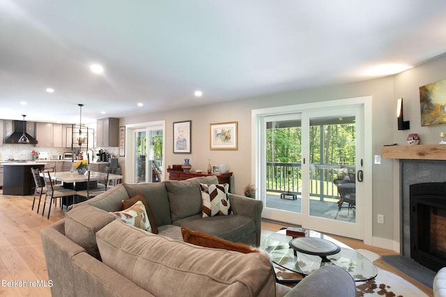 living area with a healthy amount of sunlight, light wood-style floors, a fireplace, and recessed lighting