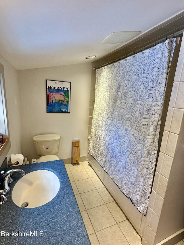 bathroom featuring shower / tub combo with curtain, a sink, toilet, and tile patterned floors