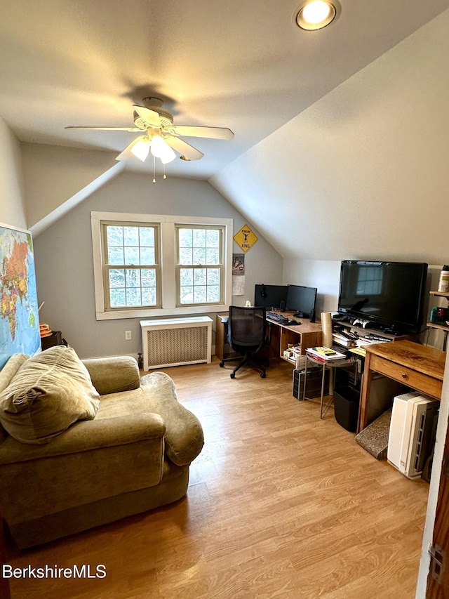 home office featuring light wood-type flooring, radiator heating unit, ceiling fan, and lofted ceiling