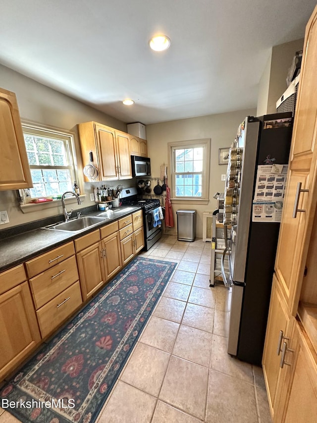 kitchen with plenty of natural light, stainless steel appliances, a sink, and light tile patterned flooring