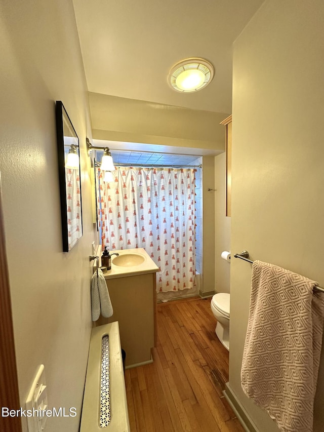 bathroom featuring toilet, vanity, hardwood / wood-style floors, and a shower with shower curtain