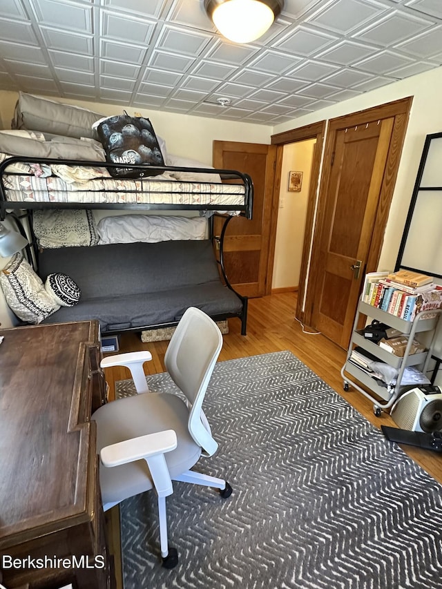 bedroom with an ornate ceiling and wood finished floors