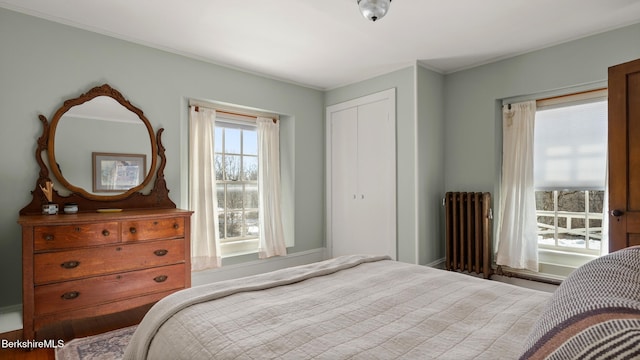 bedroom featuring radiator heating unit and a closet