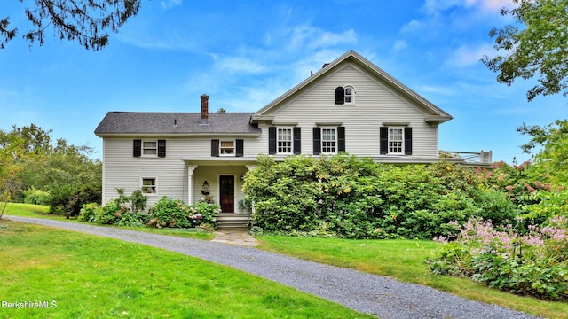 view of front facade with a front lawn and a chimney