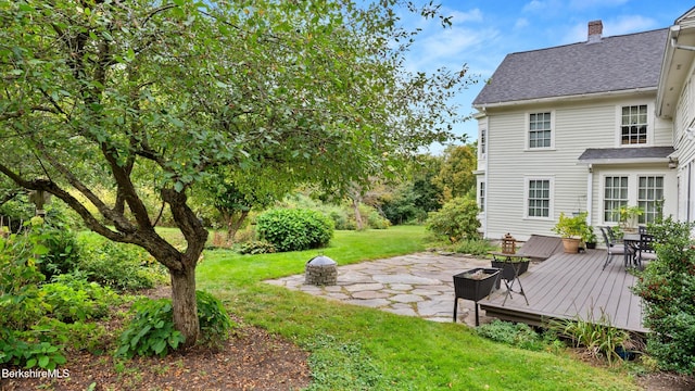 view of yard featuring a fire pit, a patio, and a deck