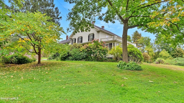 view of property exterior featuring a yard and a chimney