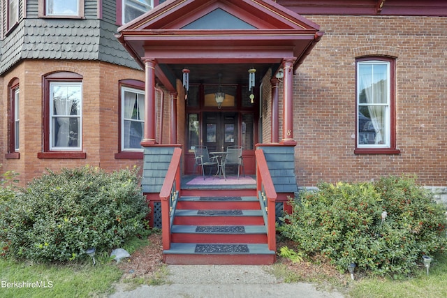 property entrance with covered porch and french doors