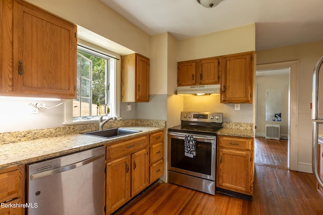 30 Belvidere Ave, Pittsfield, MA 01201 - kitchen with stainless steel appliances, under cabinet range hood, dark wood-style flooring, brown cabinets, and light stone countertops