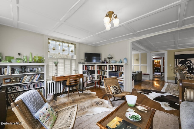 living area featuring wood finished floors, coffered ceiling, and baseboards