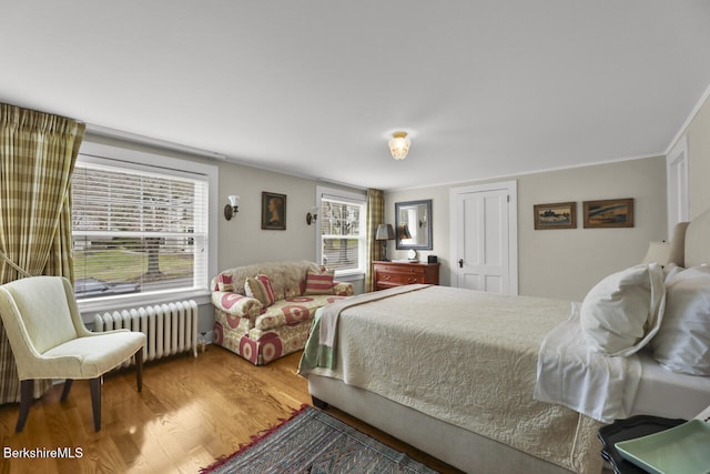 bedroom with radiator and wood finished floors