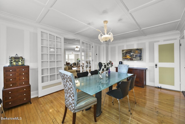 dining space with crown molding, coffered ceiling, hardwood / wood-style floors, and a chandelier