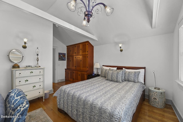 bedroom featuring lofted ceiling, a notable chandelier, and wood finished floors