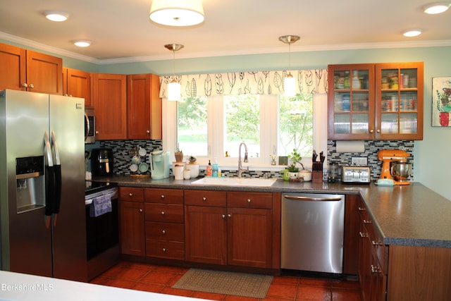 kitchen featuring appliances with stainless steel finishes, dark tile patterned floors, pendant lighting, and sink