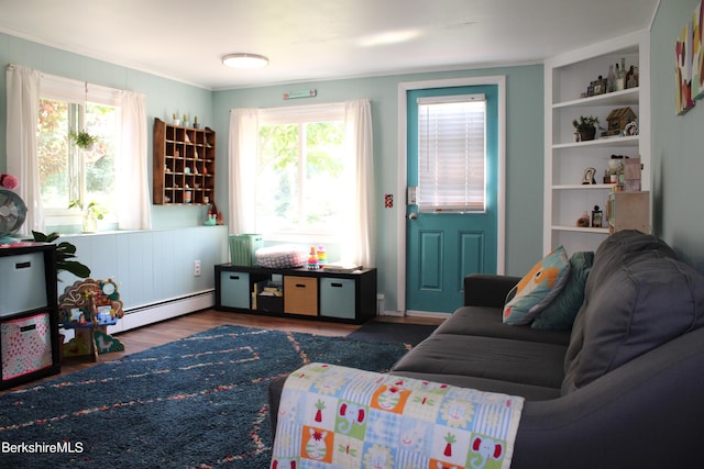 living room with ornamental molding, baseboard heating, and dark wood-type flooring