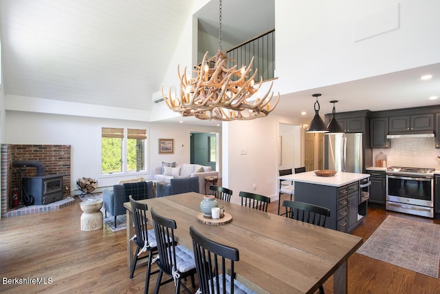 20 Hillside Ln, Sheffield, MA 01222 - dining room with dark wood-type flooring, a wood stove, a chandelier, a towering ceiling, and recessed lighting
