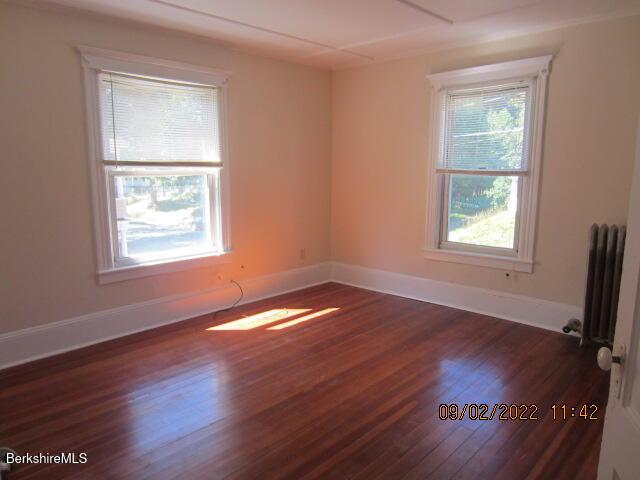 119 Appleton Ave, Pittsfield, MA 01201 - spare room with baseboards, radiator heating unit, dark wood-type flooring, and plenty of natural light
