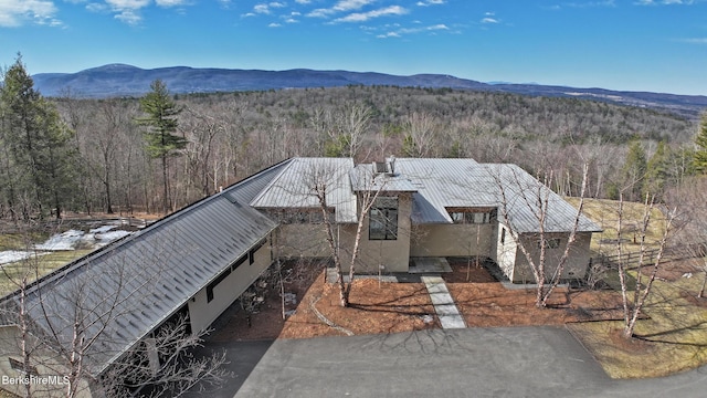 birds eye view of property with a wooded view and a mountain view