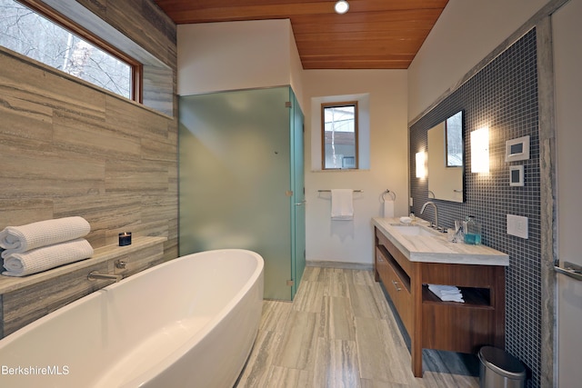 full bathroom featuring a shower stall, wood ceiling, lofted ceiling, a soaking tub, and vanity