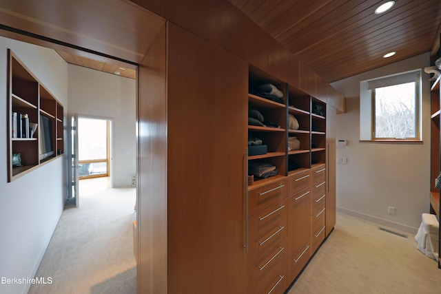 spacious closet featuring visible vents, light colored carpet, and vaulted ceiling