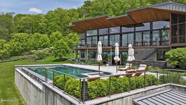 113 Brush Hill Rd, Great Barrington, MA 01230 - rear view of property with stairs, a sunroom, a pool with connected hot tub, and a lawn
