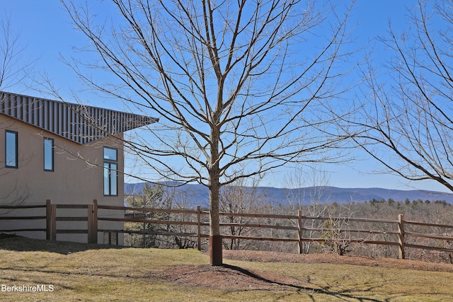 view of yard featuring a mountain view and fence