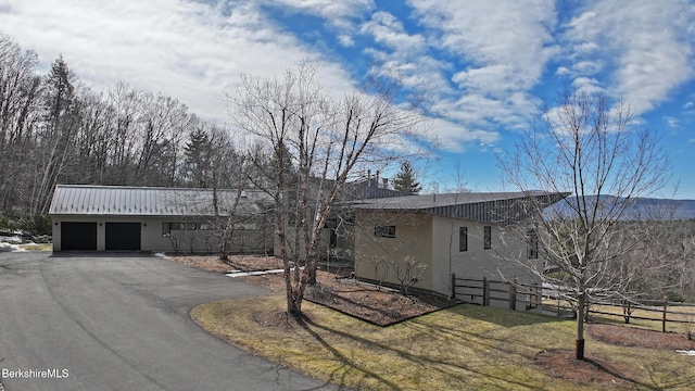 view of front of home with aphalt driveway, fence, and stucco siding