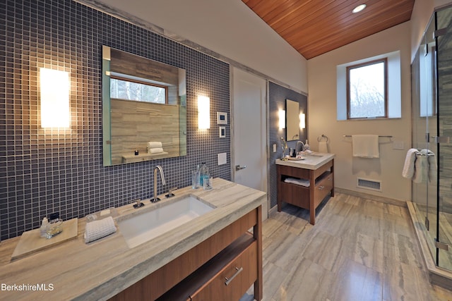 full bathroom featuring tasteful backsplash, visible vents, a shower stall, vaulted ceiling, and a sink