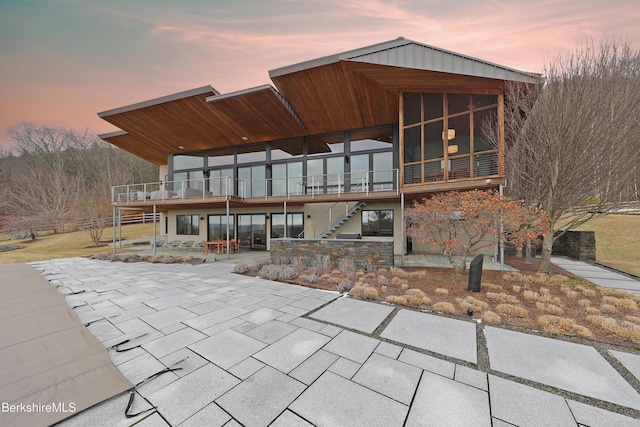 back of house with a patio area, stairway, a wooden deck, and a sunroom