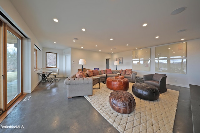 living area featuring visible vents, recessed lighting, finished concrete flooring, and baseboards