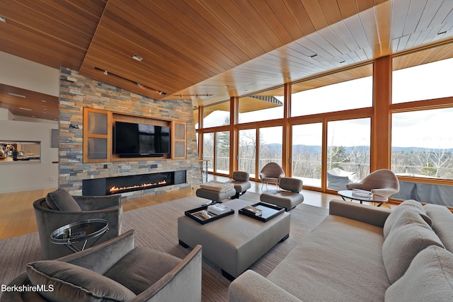 living room featuring floor to ceiling windows, a fireplace, wooden ceiling, wood finished floors, and high vaulted ceiling