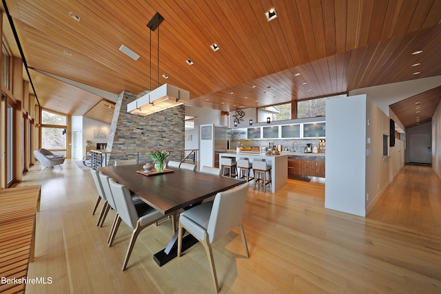 dining area with wood ceiling, light wood-style floors, and vaulted ceiling