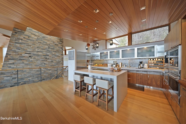 kitchen with wood ceiling, modern cabinets, brown cabinets, and oven