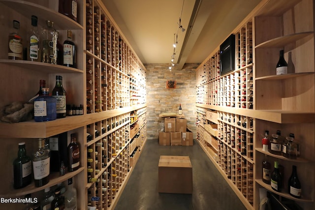 wine area with finished concrete floors and track lighting