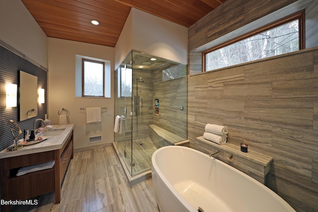 bathroom with a freestanding tub, wooden ceiling, and a shower stall