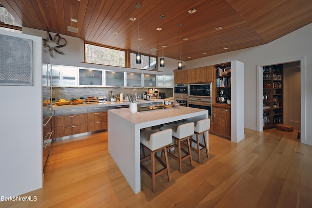 kitchen with wood ceiling, tasteful backsplash, modern cabinets, and brown cabinets