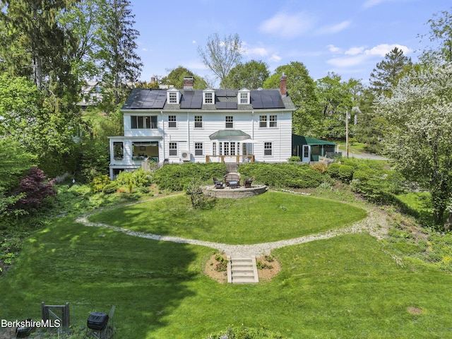 68 Colt Rd, Pittsfield, MA 01201 - back of property featuring solar panels, a deck, a yard, a chimney, and view of wooded area