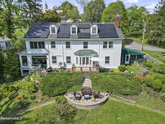68 Colt Rd, Pittsfield, MA 01201 - rear view of house with a chimney, solar panels, stairway, and a wooden deck