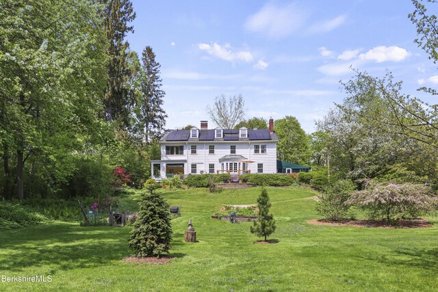 68 Colt Rd, Pittsfield, MA 01201 - back of property with roof mounted solar panels, a lawn, and a chimney