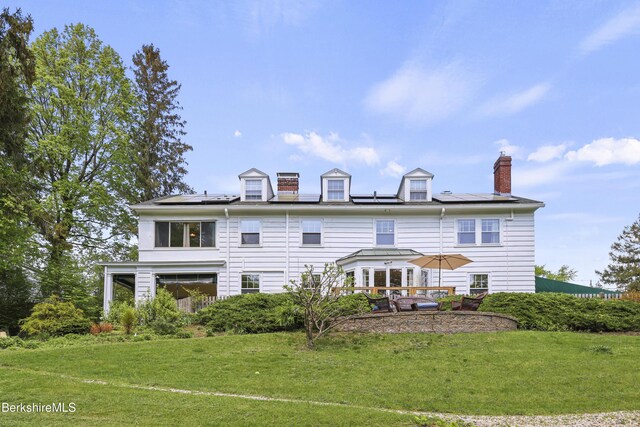 68 Colt Rd, Pittsfield, MA 01201 - rear view of house featuring a yard, a chimney, and roof mounted solar panels