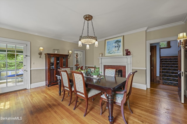 68 Colt Rd, Pittsfield, MA 01201 - dining space featuring light wood-style floors, stairway, baseboards, crown molding, and a brick fireplace