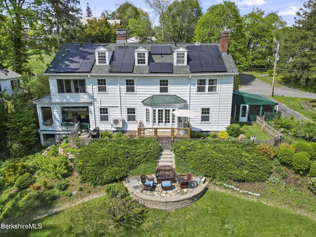 68 Colt Rd, Pittsfield, MA 01201 - rear view of house with a chimney, solar panels, stairway, and a wooden deck